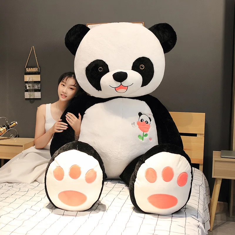 Black and white giant panda hugging panda plush toy